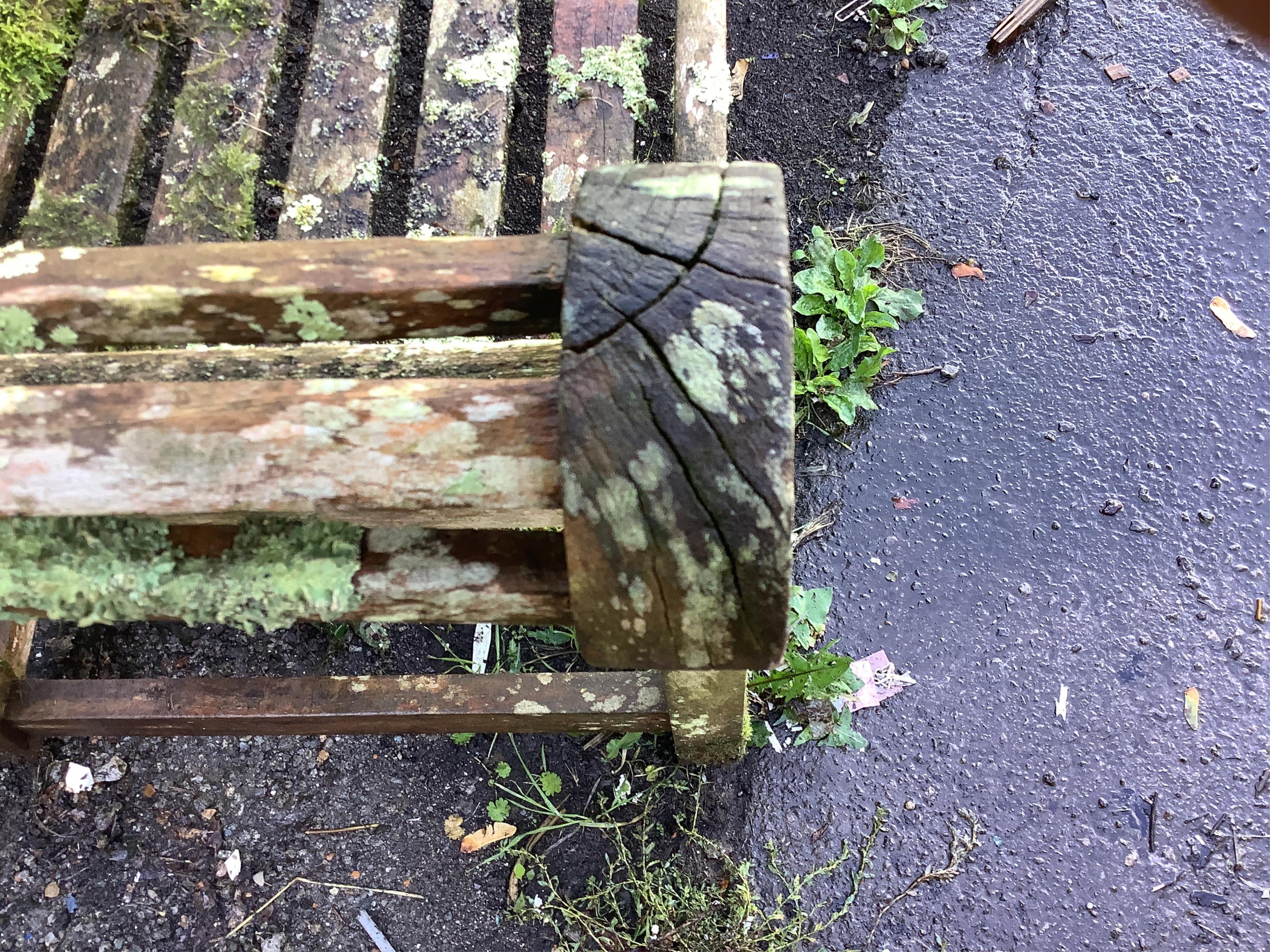 A weathered teak Lutyens style garden bench, width 165cm, depth 58cm, height 103cm. Condition - poor, covered in moss and lichen